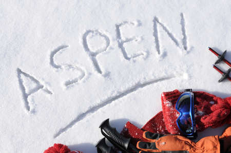 The word Aspen written in snow with ski poles and clothing.の写真素材