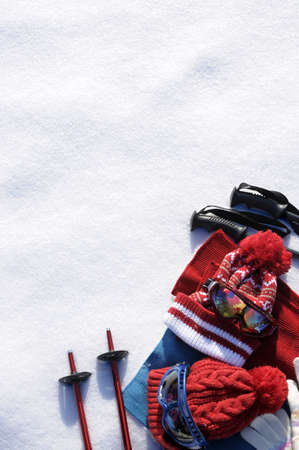 Winter snow sports background with ski poles, goggles, hats and gloves with copyspace.の写真素材