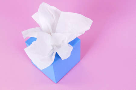 Paper tissues in blank blue box on a pink background.の写真素材