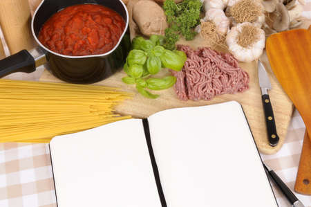 Making Italian spaghetti bolognese with ingredients and blank recipe book or cookbook. Space for copy.の写真素材