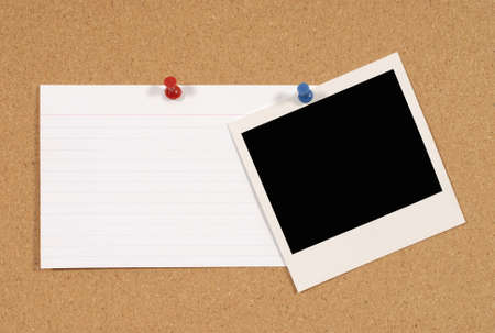 Cork notice or bulletin board with blank instant camera photo print and white office index card. Space for copy.の写真素材