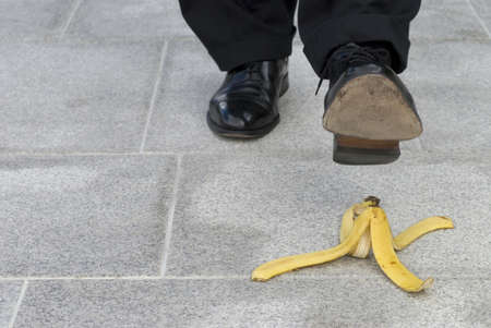 Businessman about to step on a banana skinの写真素材