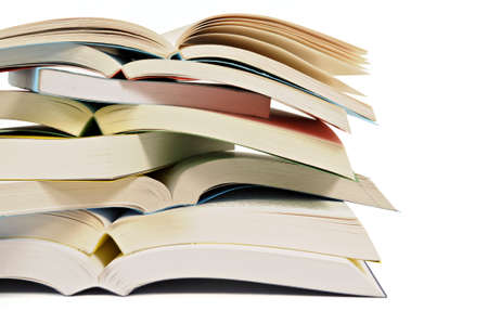 Untidy stack or pile of open paperback books isolated on a white background.  Space for copy.の写真素材