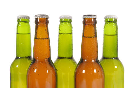 Closeup of a row of beer bottles against a white backgroundの写真素材