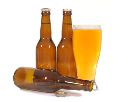 Glass of beer with untidy cluster of brown bottlesの写真素材