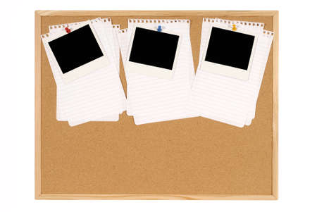 Cork notice or bulletin board with blank instant camera photo prints and several sheets of untidy torn notepaper. Space for copy.の写真素材