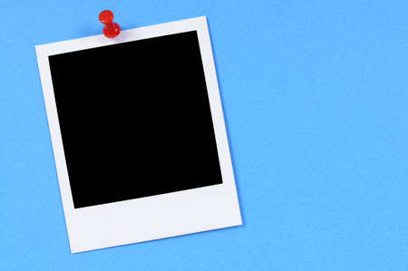 Blank photo print pinned to blue paper.