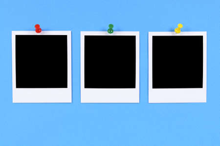 Blank photo prints pinned to blue paper.の写真素材