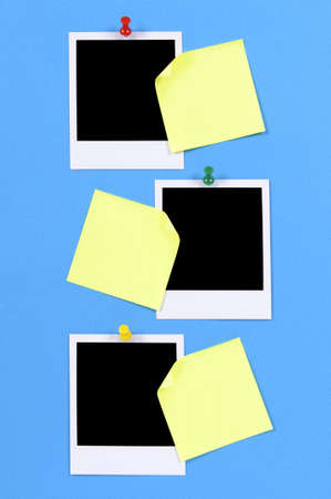 Blank photo prints with sticky notes pinned to blue paper.の写真素材