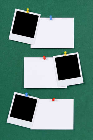 Blank photo prints with office index cards pinned to a green felt notice board.の写真素材