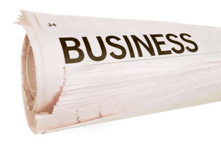 Rolled up newspaper with business headlines set against a white backgroundの写真素材
