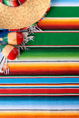 Mexican background with sombrero straw hat, maracas and traditional serape blanket or rug.  Space for copy.の写真素材