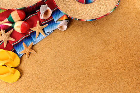 Mexican beach background with sombrero straw hat, traditional serape blanket, starfish, seashells and maracas.  Space for copy.の写真素材