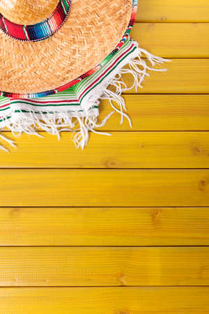 Mexican sombrero and traditional serape blanket laid on a yellow painted pine wood floor.  Space for copy.の写真素材