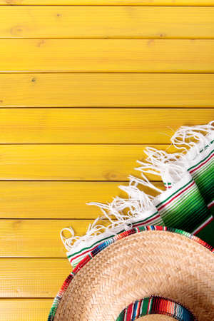Mexican sombrero and traditional serape blanket laid on a yellow painted pine wood floor.  Space for copy.の写真素材