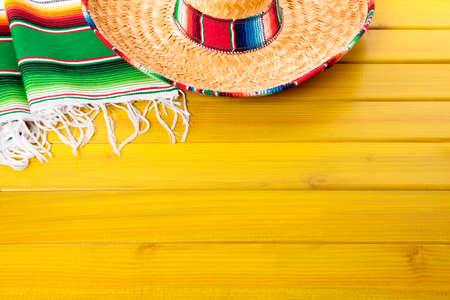 Mexican sombrero and traditional serape blanket laid on a yellow painted pine wood floor.  Space for copy.の写真素材