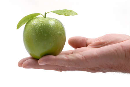Green apple with leaves and water drops  in male handの写真素材