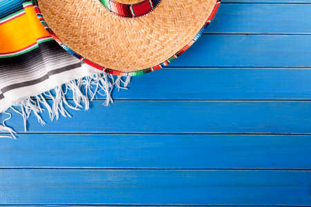 Mexican sombrero and traditional serape blanket laid on an old blue painted pine wood floor.  Space for copy.の写真素材