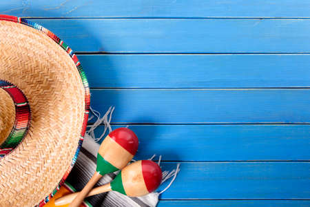 Mexican sombrero and maracas with traditional serape blanket laid on an old blue painted pine wood floor.  Space for copy.の写真素材