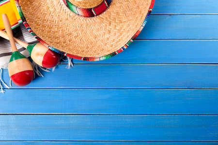 Mexican sombrero and maracas with traditional serape blanket laid on an old blue painted pine wood floor.  Space for copy.の写真素材