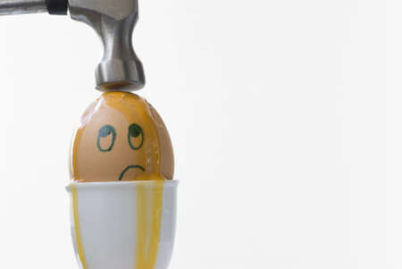 Boiled egg about to be broken by a hammer.  Copy space on right.の写真素材