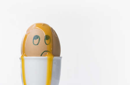 An unhappy, confused and dazed boiled egg.  Copy space on right.の写真素材