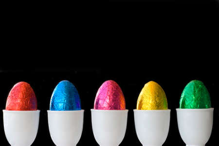 A line of colourful eggs.  Space for copy on black backgroundの写真素材