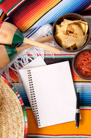 Mexican sombrero with traditional blankets, nachos, salsa dip and notebookの写真素材