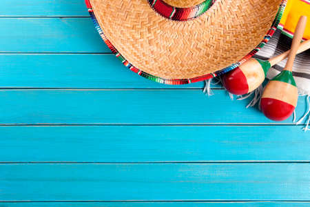 Mexican sombrero and maracas with traditional serape blanket laid on an old blue painted pine wood floor.  Space for copy.の写真素材