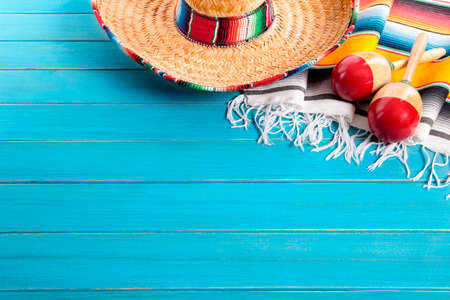 Mexican sombrero and maracas with traditional serape blanket laid on an old blue painted pine wood floor.  Space for copy.の写真素材