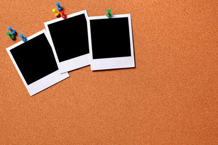 Three blank photo prints pinned to a cork notice board.  Space for copy.  Paths provided.の写真素材