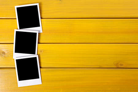 Three blank photo prints on a wood desk or table.  Space for copy.の写真素材