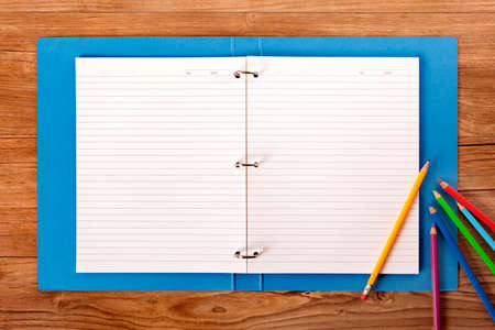 Student\'s desk with blue project folder and various pencilsの写真素材