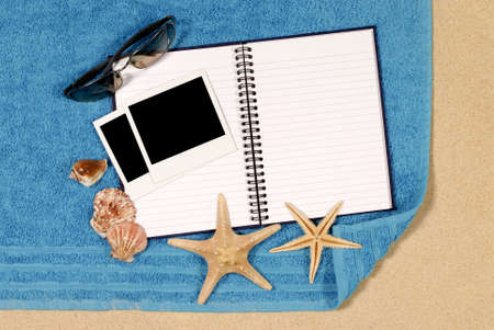 Beach scene with blank writing book and  photo printsの写真素材