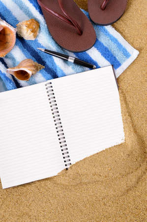 Beach background with towel, flip flops and blank notebook.の写真素材