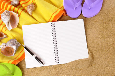 Beach background with towel, flip flops and blank writing book.の写真素材