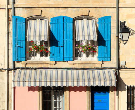 Typical French provencal style windows with blue shutters and flower boxes.の写真素材