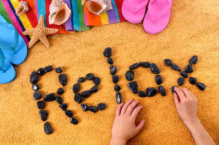 The word Relax written with seashells on a sandy beachの写真素材