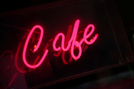 Vivid pink neon cafe sign with reflection.の写真素材