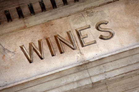 Very old wine sign carved into the stone entrance of a wine cellar.の写真素材