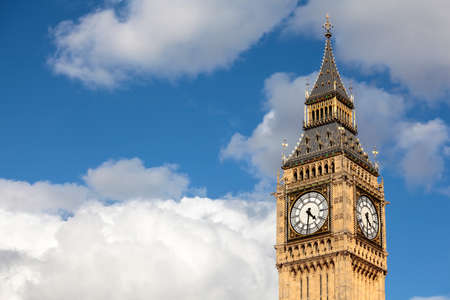 Big Ben clock tower isolated against a deep blue cloudy summer sky.  Space for copy.