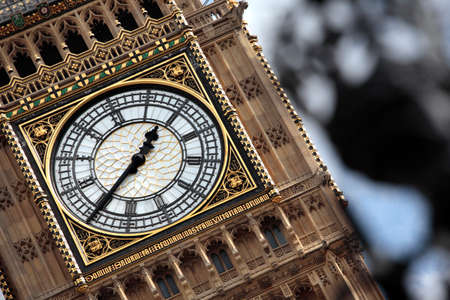 View of Big Ben clock tower with the wrought iron railings of the Houses of Parliament deliberately out of focus in the foreground.の写真素材