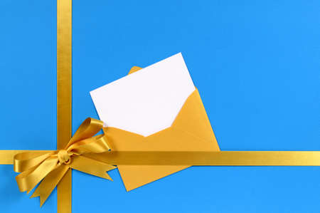 Blue and gold gift with blank invitation or greetings card.の写真素材