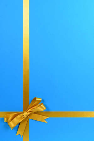Gold gift ribbon on blue background.の写真素材