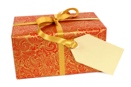 Red and gold gift with ribbon and gift tag label isolated on white backgroundの写真素材