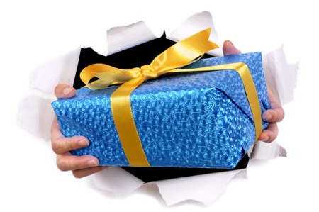 Man hands delivering or giving gift through torn white paper backgroundの写真素材