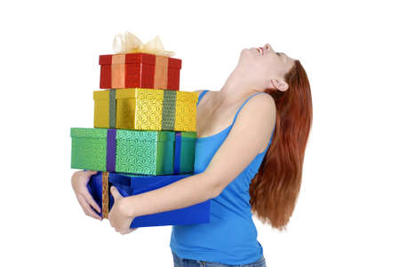 Young adult woman in casual clothes with pile of Christmas or birthday gifts isolated on white...