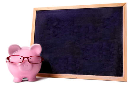 Piggy bank wearing glasses with small blank blackboard, isolated on white backgroundの写真素材