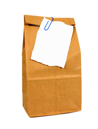 Brown paper lunch or groceries bag with torn note paper isolated on whiteの写真素材