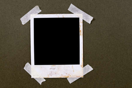 Old vintage stained style blank photo print frame taped to brown paper backgroundの写真素材